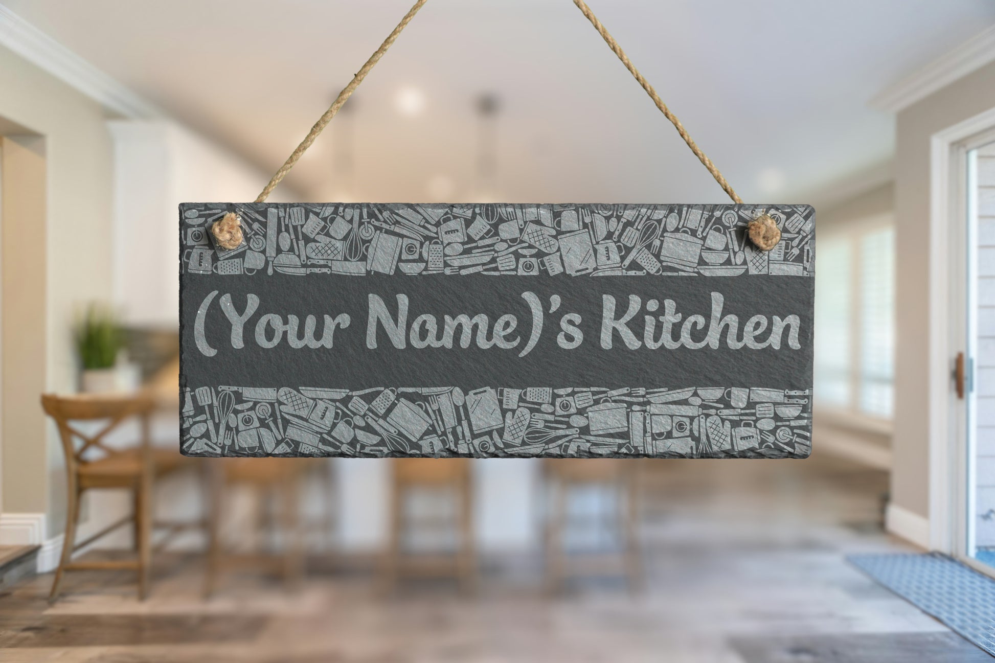 Decorative slate sign with 'Your Name's Kitchen' text hanging in a kitchen.