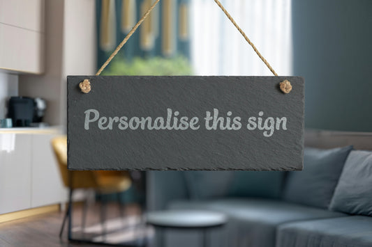 Slate sign with 'Personalise this sign' text in a living room setting