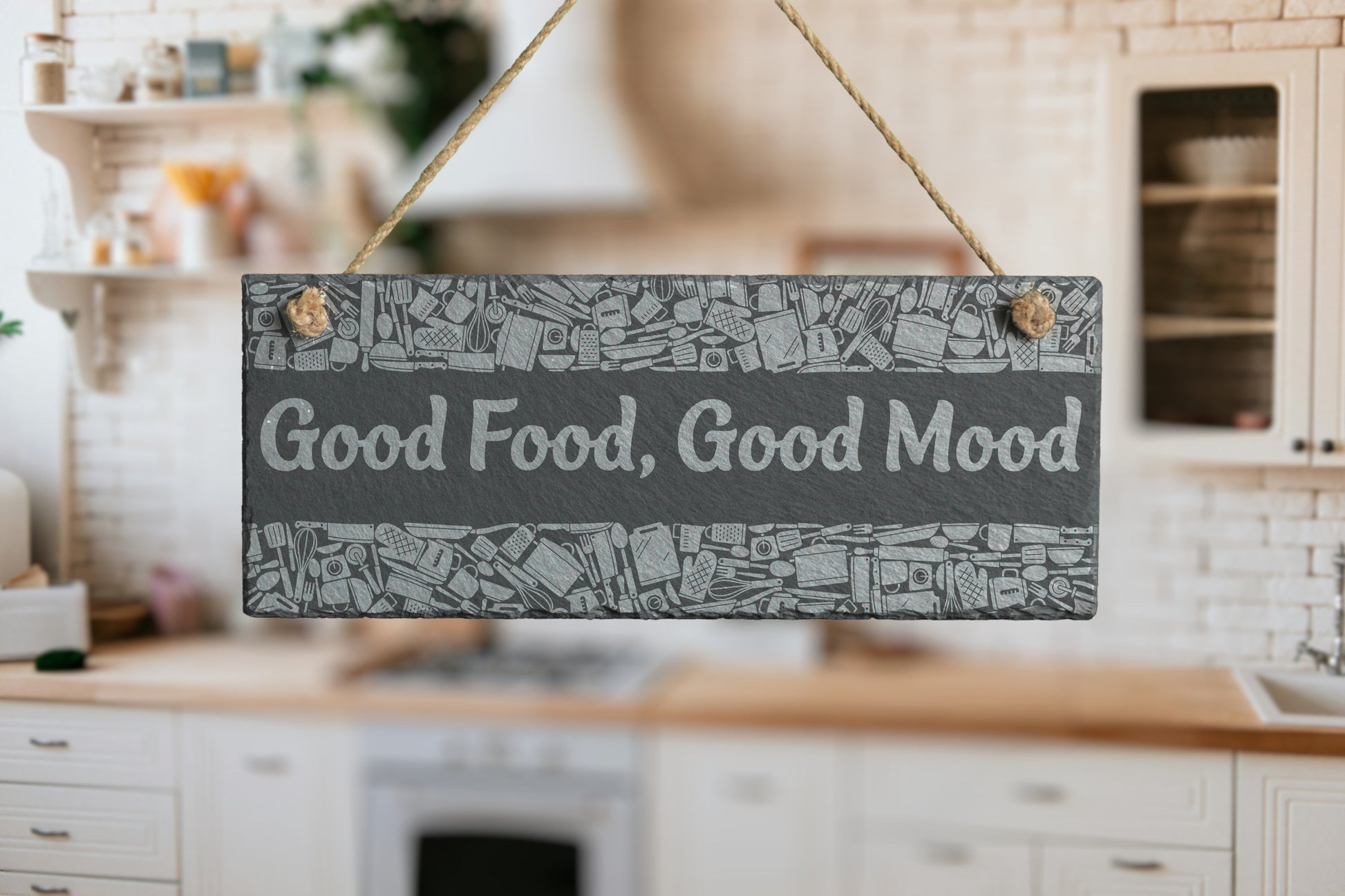 Customizable slate sign with engraved kitchen utensil border and the text 'Good Food, Good Mood', hanging in a modern kitchen setting.