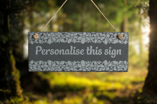 Decorative slate sign with 'Personalise this sign' text in a forest setting