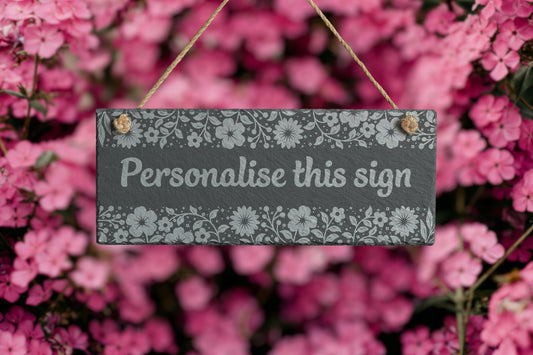 Decorative sign with floral pattern and text 'Personalise this sign' against a pink floral background